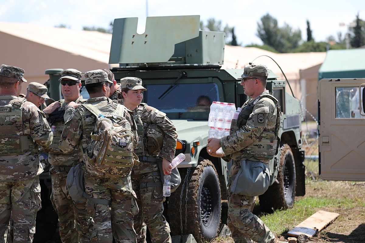 Soldiers handing out bottles of water from the back of a truck