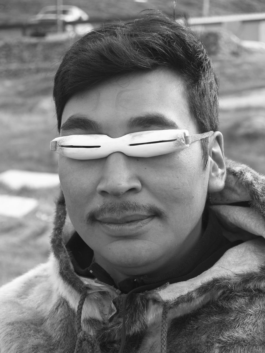 A man wearing carved slit goggles across his eyes