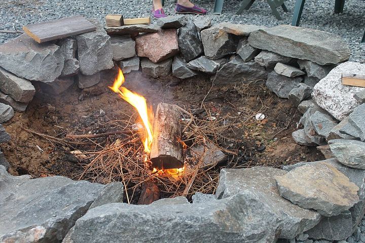 Small twigs and pine needles burning in a stone fire ring