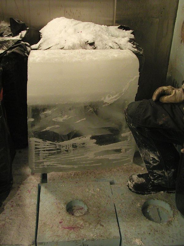 A block of ice with clear dense ice at the bottom and white snowy ice on top