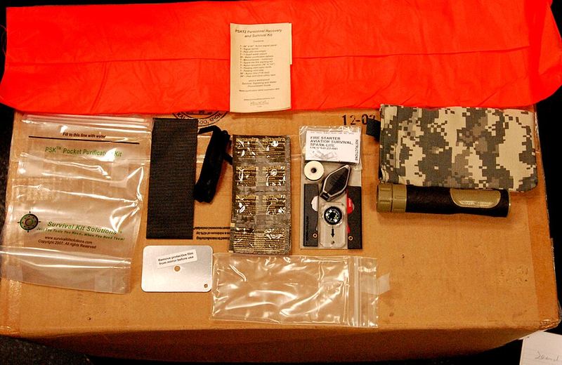 A pocket survival kit laid out with a blister pack of iodine tablets in the middle